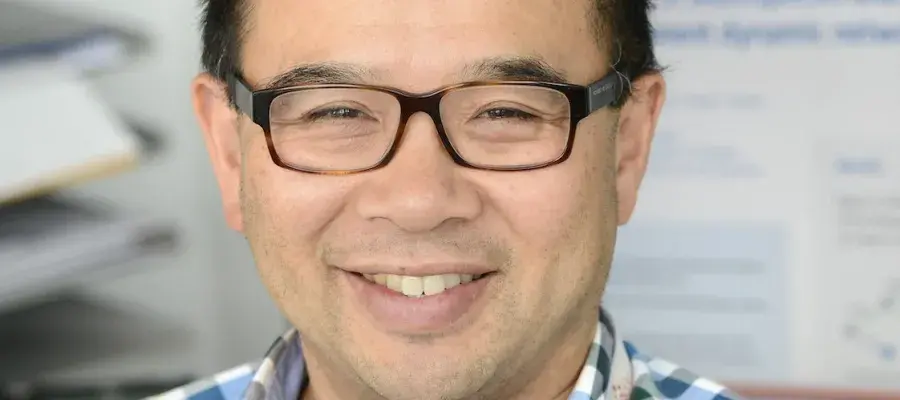 Professor Rowland Kao smiles while sitting at his desk